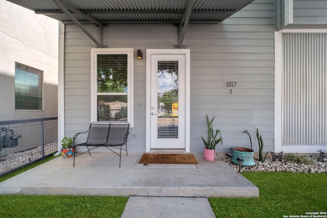 property entrance featuring a lawn