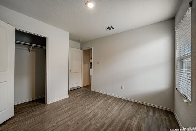 unfurnished bedroom featuring hardwood / wood-style flooring and a closet