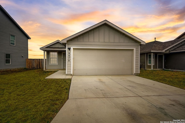 ranch-style house with a garage and a lawn