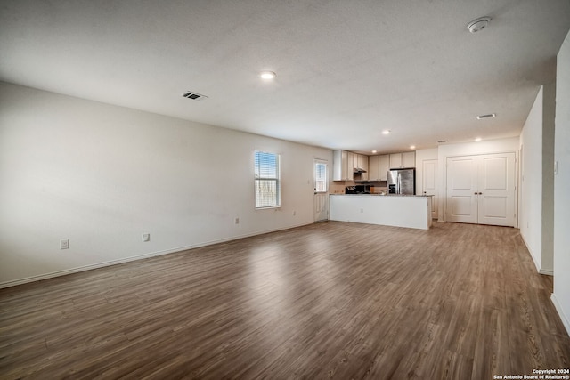 unfurnished living room featuring hardwood / wood-style floors