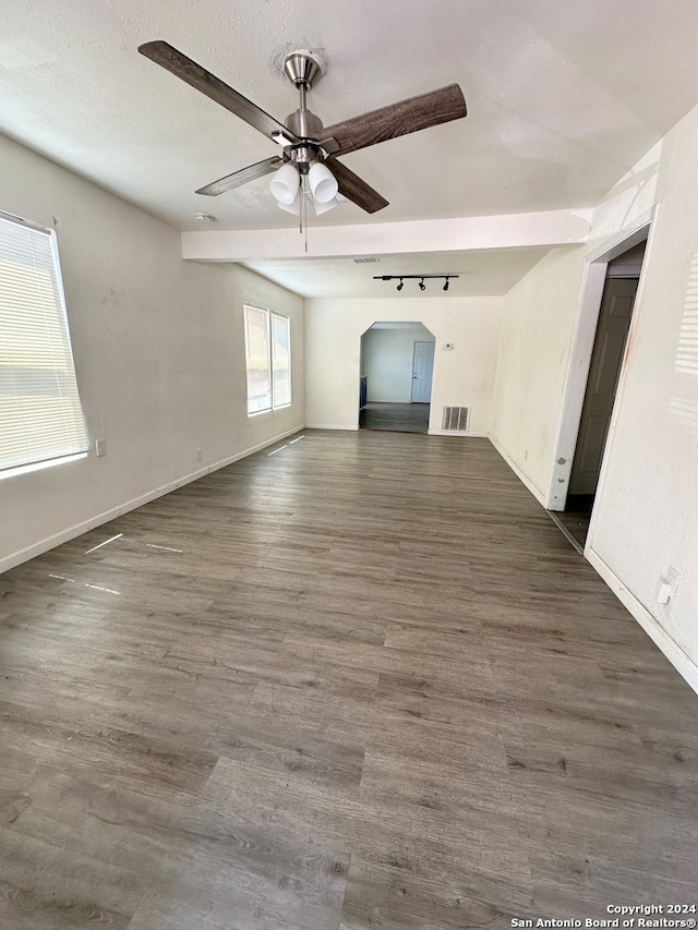 unfurnished living room featuring dark hardwood / wood-style floors, a textured ceiling, rail lighting, and ceiling fan