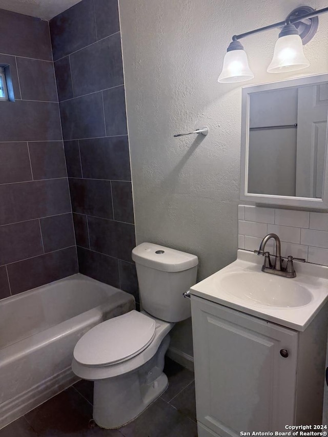 full bathroom featuring vanity, tile patterned floors, tiled shower / bath combo, toilet, and tasteful backsplash