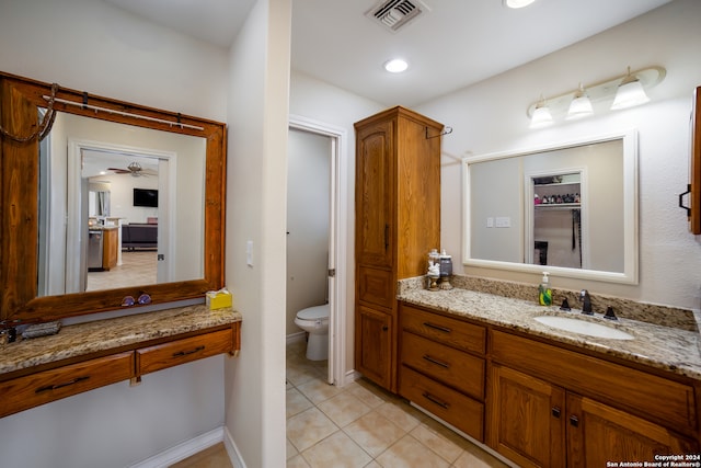 bathroom featuring vanity, toilet, tile patterned flooring, and ceiling fan