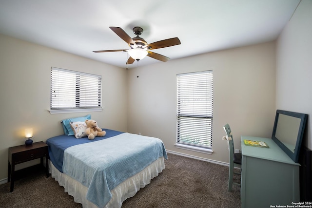 bedroom featuring dark colored carpet, multiple windows, and ceiling fan