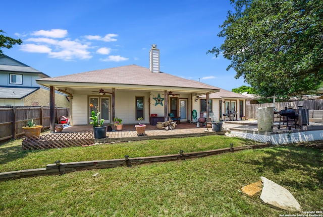 back of property with a yard and ceiling fan