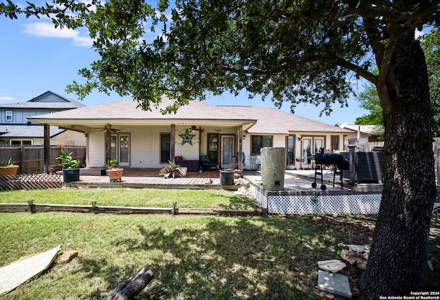 rear view of property with a wooden deck and a lawn