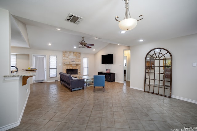 living room featuring light tile patterned floors, a fireplace, ceiling fan, and lofted ceiling