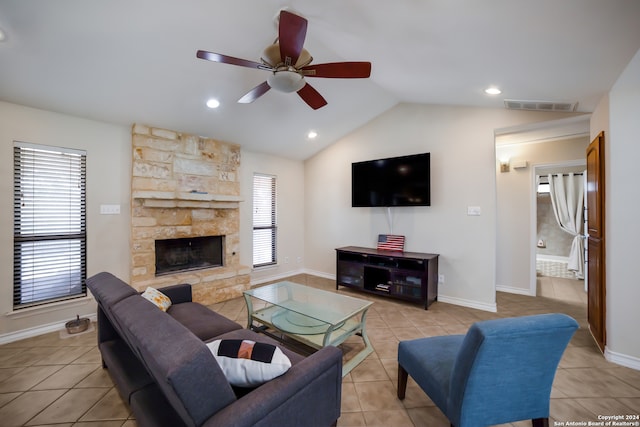 living room featuring light tile patterned flooring, a fireplace, lofted ceiling, and ceiling fan