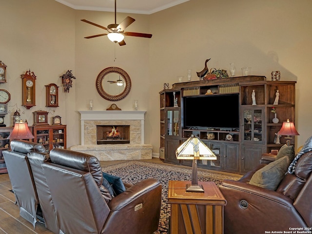 living room with hardwood / wood-style flooring, a fireplace, crown molding, and ceiling fan