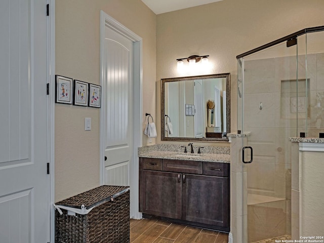 bathroom featuring a shower with door, wood-type flooring, and vanity