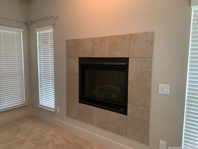 room details featuring carpet and a tile fireplace