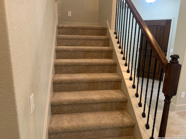 stairway with light tile patterned floors