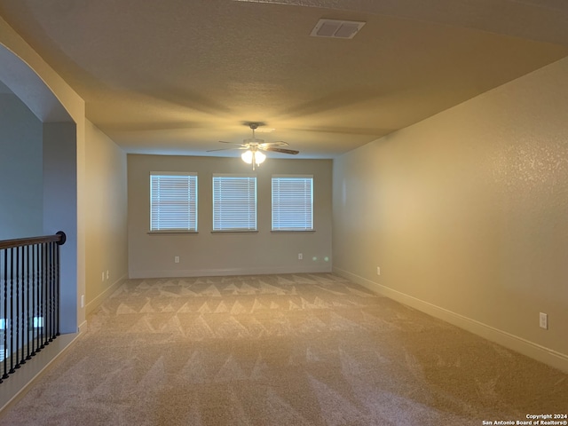 carpeted spare room featuring ceiling fan