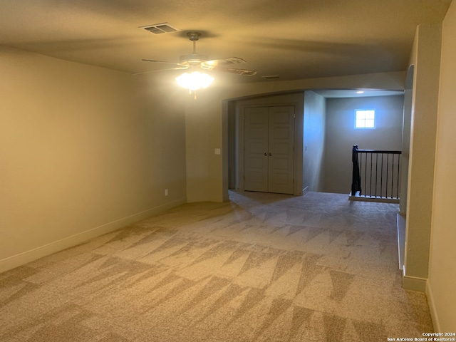 spare room featuring light colored carpet and ceiling fan