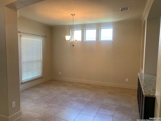 unfurnished dining area featuring a chandelier, crown molding, and light tile patterned floors