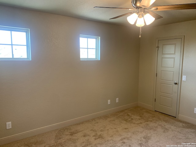 carpeted spare room with ceiling fan