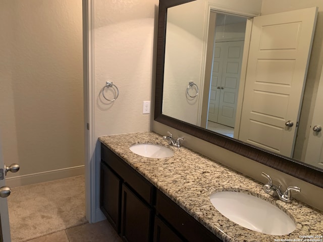 bathroom with tile patterned floors and double vanity