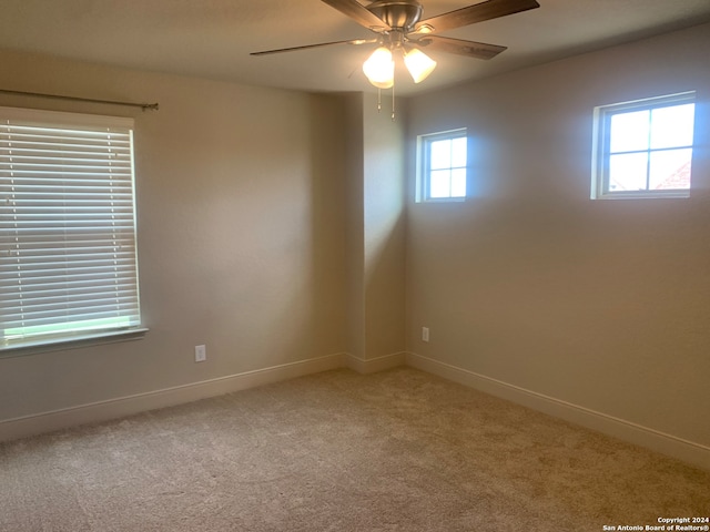 carpeted spare room featuring ceiling fan