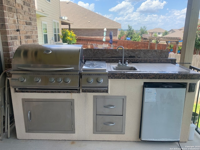 view of patio with grilling area and sink