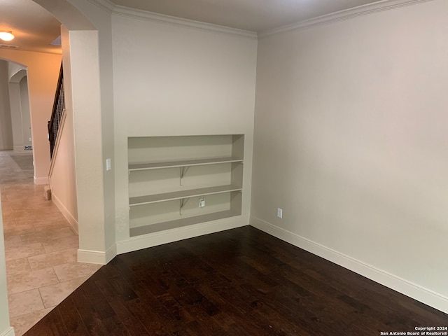 spare room with crown molding and light hardwood / wood-style flooring