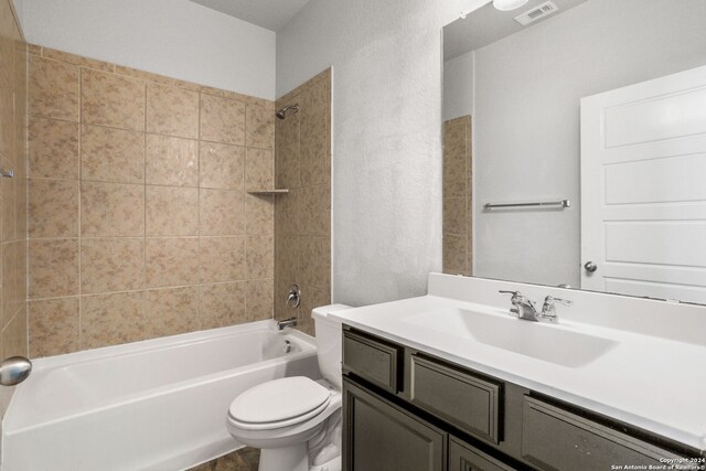 full bathroom with vanity, tiled shower / bath, and toilet