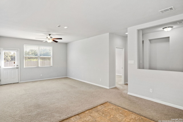 carpeted spare room featuring ceiling fan