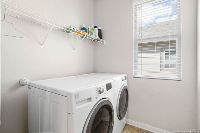 washroom with washing machine and clothes dryer and light tile patterned floors