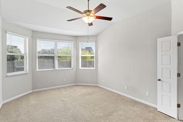 spare room with lofted ceiling, light colored carpet, and ceiling fan