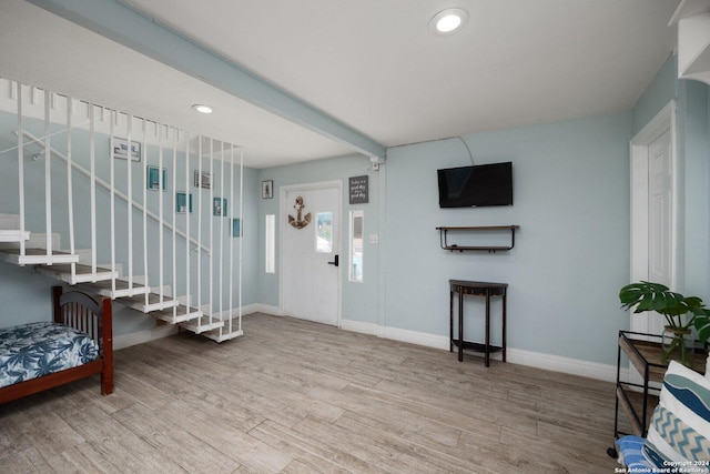 entryway with beam ceiling and light hardwood / wood-style flooring