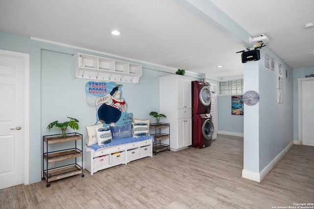 mudroom featuring stacked washer / drying machine and light hardwood / wood-style flooring