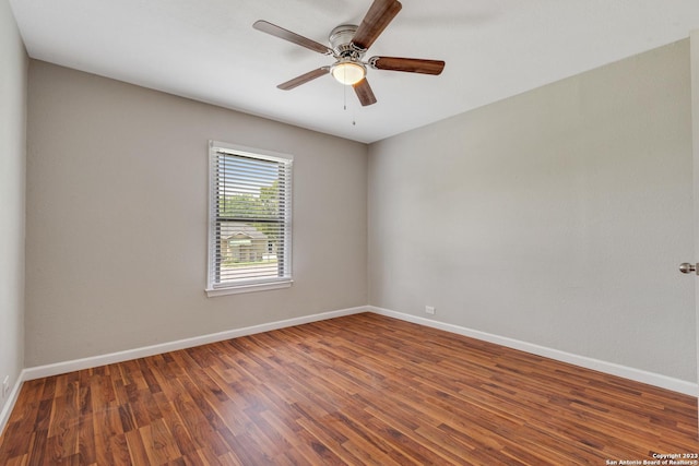 spare room featuring wood finished floors, a ceiling fan, and baseboards