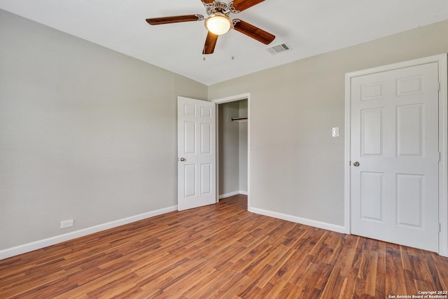 unfurnished bedroom featuring baseboards, visible vents, ceiling fan, and wood finished floors