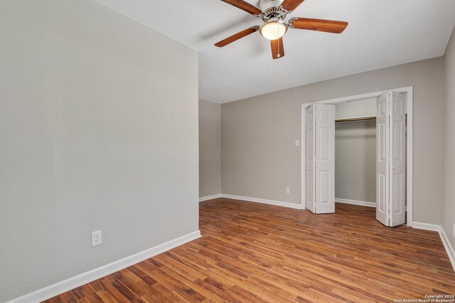 unfurnished bedroom with hardwood / wood-style flooring, a closet, and ceiling fan