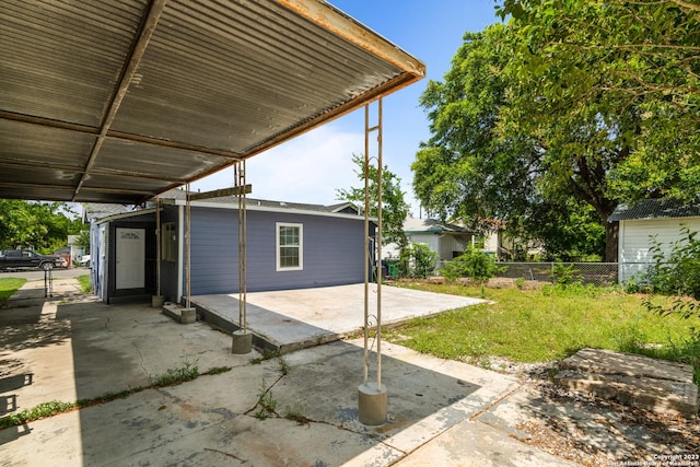 view of patio / terrace with a carport and fence