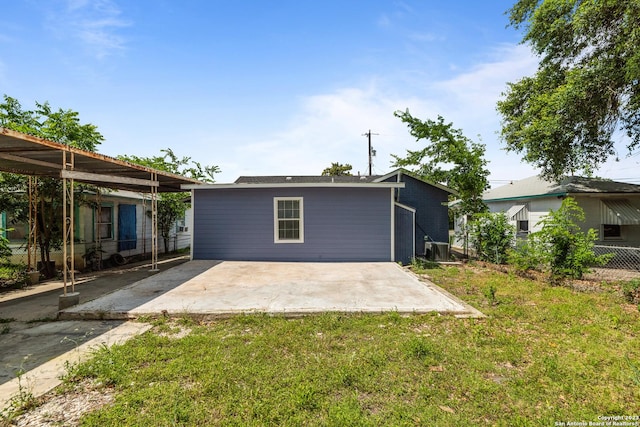 rear view of property with central air condition unit, fence, a lawn, and a patio