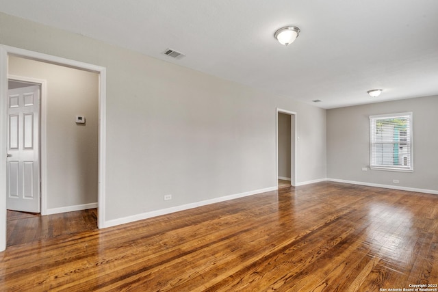 spare room featuring visible vents, baseboards, and hardwood / wood-style floors