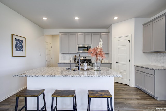 6934 Comanche Cave, San Antonio, TX 78233 - kitchen with light stone countertops, stainless steel appliances, decorative backsplash, and gray cabinets