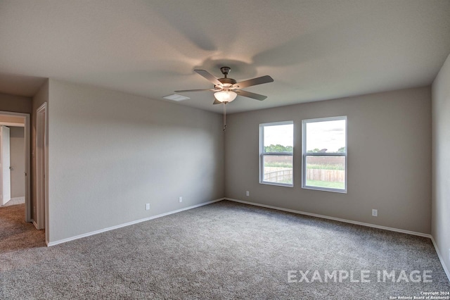 carpeted empty room featuring ceiling fan, visible vents, and baseboards