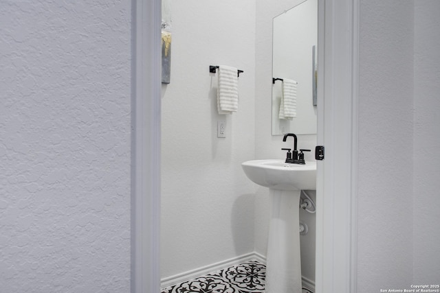 6934 Comanche Cave, San Antonio, TX 78233 - bathroom featuring a textured wall and baseboards