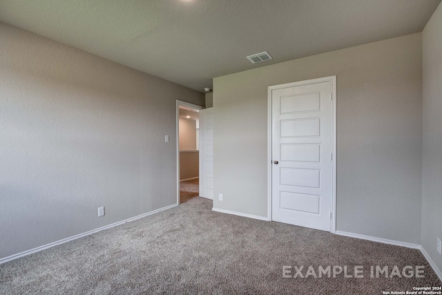 unfurnished bedroom featuring carpet, visible vents, and baseboards