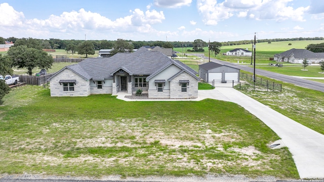 view of front facade featuring an outbuilding, a garage, and a front lawn