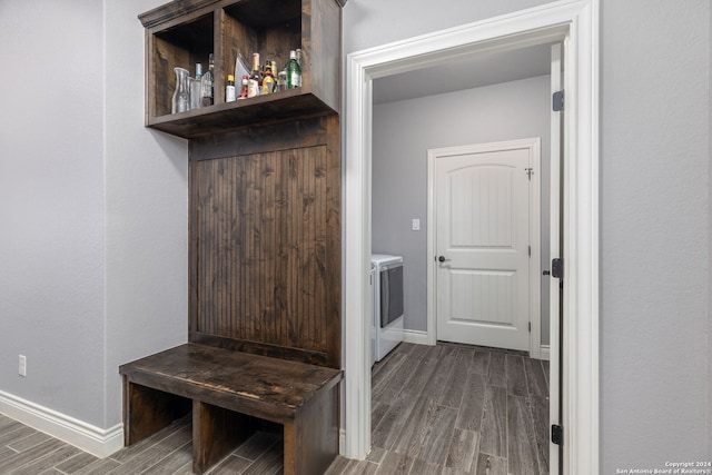 mudroom with dark wood-type flooring and washing machine and clothes dryer