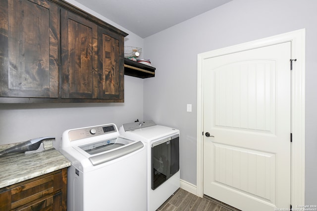 washroom with washer and clothes dryer, cabinets, and dark wood-type flooring