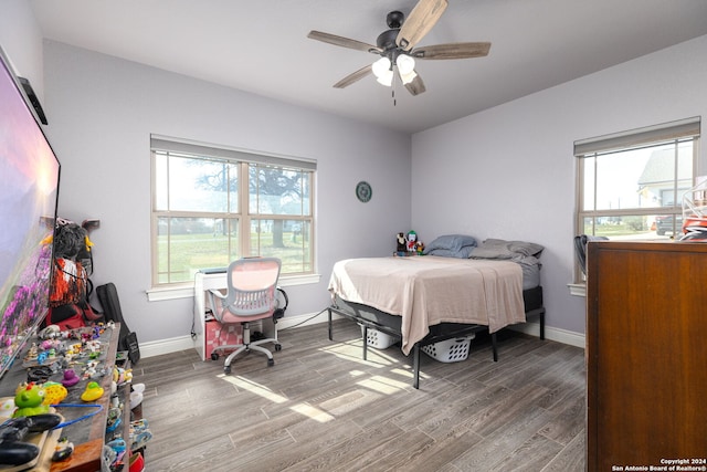 bedroom with multiple windows and hardwood / wood-style flooring