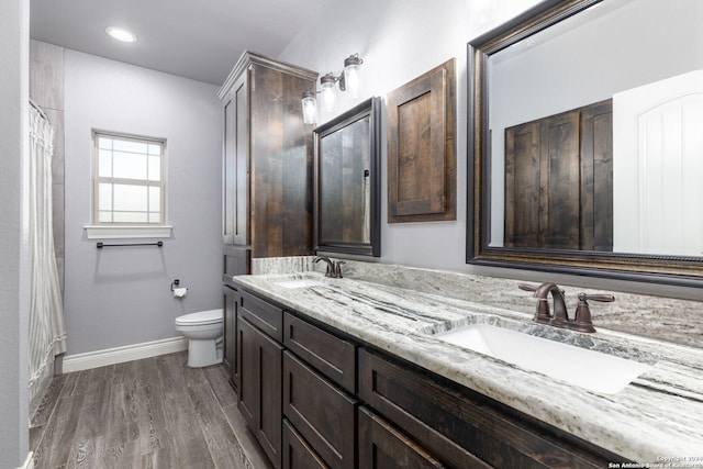 bathroom featuring wood-type flooring, vanity, and toilet