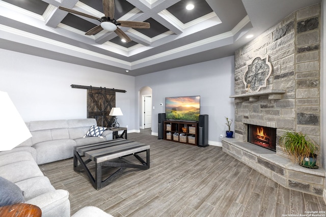 living room with wood-type flooring, ornamental molding, ceiling fan, and a fireplace