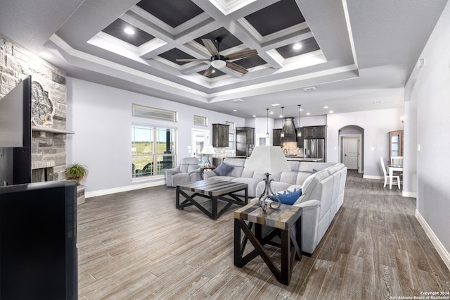 living room with ceiling fan, ornamental molding, a fireplace, and hardwood / wood-style floors