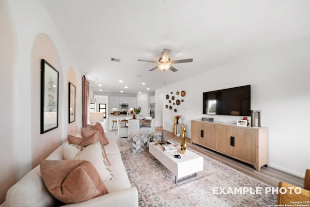 living room with light hardwood / wood-style floors and ceiling fan