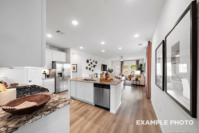 kitchen with appliances with stainless steel finishes, white cabinetry, and light stone countertops