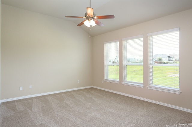 carpeted spare room with ceiling fan and vaulted ceiling